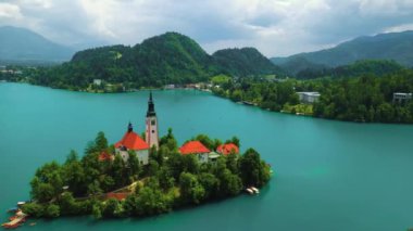 Mary 'nin Varsayımı Kilisesi' nin göl merkezindeki hava manzarası Bled. Slovenya 'daki Bled Gölü' nde küçük bir adada uçmak, canlı mavi su, 4k drone videosu