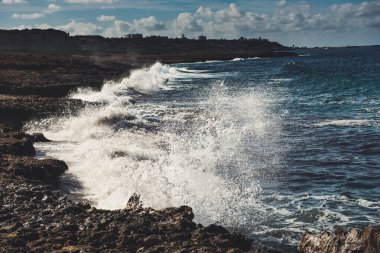 Kayalara su sıçratan deniz dalgaları, doğal tatil mahsulü hipster sezonluk arka plan. Kıbrıs