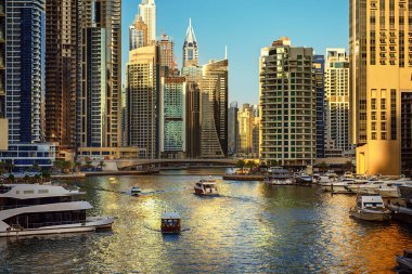 Gün batımından önce Dubai Marina 'da gökdelenler, botlar ve deniz yansımaları, Birleşik Arap Emirlikleri