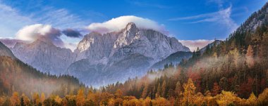 Güneşin doğuşuyla Triglav dağı zirvesi sabah ışığında güzel bulutlarla. Slovenya, Triglav Ulusal Parkı