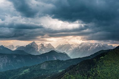 Julian Alplerinde Triglav dağları üzerinde dramatik karanlık bulutlu gökyüzü olan yaz manzarası - mevsimsel seyahat arka planı