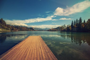 Ahşap iskele Gölü Bled, Slovenya Sonbaharda mavi gökyüzü ve bulutlarla