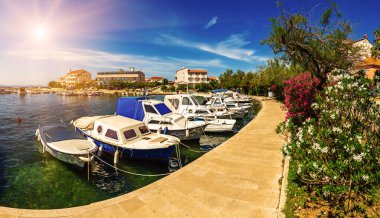 Coastal village of Petrcane in Dalmatia, Croatia with blue sea water and yachts, travel destination touristic background clipart