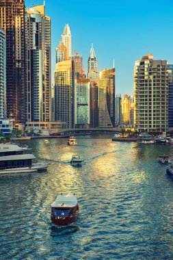 Gün batımından önce Dubai Marina 'da gökdelenler, botlar ve deniz yansımaları, Birleşik Arap Emirlikleri