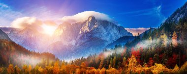 Güneşin doğuşuyla Triglav dağı zirvesi sabah ışığında güzel bulutlarla. Slovenya, Triglav Ulusal Parkı