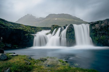 Kirkjufell yanardağının Snaefellsnes yarımadasının kıyısındaki muhteşem manzarası. Resimli ve muhteşem bir sahne. Kirkjufellsfoss Şelalesi, İzlanda, Avrupa 'da ünlü bir yer. Güzellik dünyası.