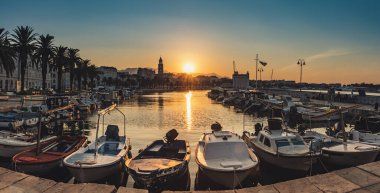 Güneşin doğuşuyla birlikte güzel Split şehrinin panoramik manzarası setle, palmiyelerle, yatlarla ve denizde yüzen teknelerle. Hırvatistan ve Avrupa: Seyahat kavramı.