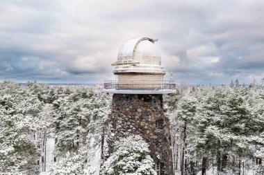 Old observatory tower in the Glen park. Tallinn, Estonia, against dramatic sky. Winter seasonal landscape. clipart