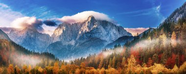 Güneşin doğuşuyla Triglav dağı zirvesi sabah ışığında güzel bulutlarla. Slovenya, Triglav Ulusal Parkı