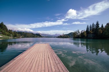 Ahşap iskele Gölü Bled, Slovenya Sonbaharda mavi gökyüzü ve bulutlarla