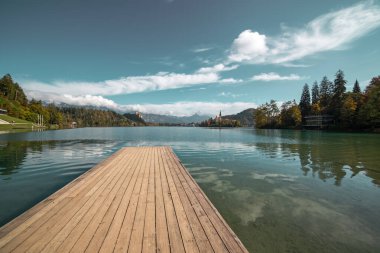 Ahşap iskele Gölü Bled, Slovenya Sonbaharda mavi gökyüzü ve bulutlarla