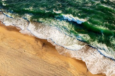 Soyut okyanus sahili arka planı. Yaratıcı minimum plaj konsepti. Mavi yeşil su, dalga ve kum ile yaz tatili planı. Düz yatıyordu. Yukarıdan bak. Portekiz manzarası