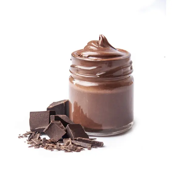 玻璃瓶中的巧克力飞溅 带有白色背景的巧克力片 免版税图库照片