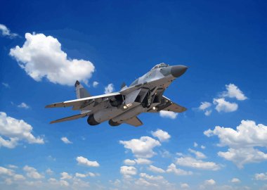 Avcı jeti mavi gökyüzü ve beyaz bulutlara karşı yüksekten uçuyor.