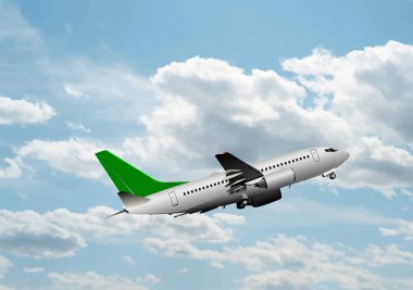 Mavi arka planda bulutların üzerinde uçan yolcu uçağı