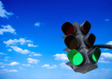 Yeşil trafik ışığı mavi gökyüzünün altında bulutların altında hareket izni veriyor.