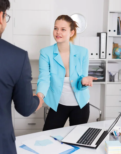 女性の会社のマネージャーは職場で握手で男性クライアントに会う — ストック写真