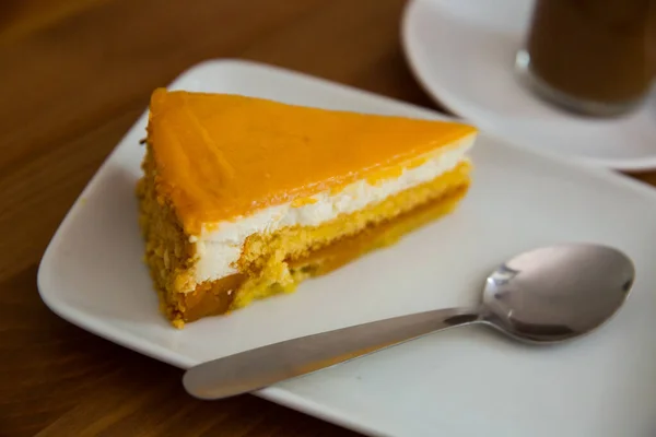 Slice of pumpkin cheesecake on white plate, modern dessert