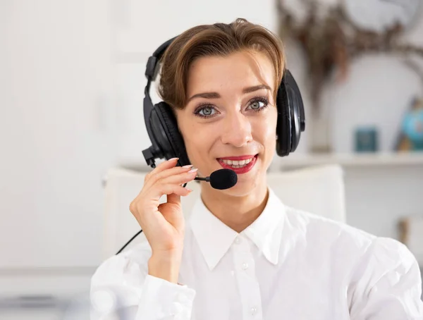 Happy call center operator talking with client and smiling