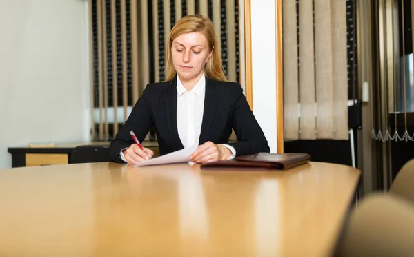 オフィスの会議室に座って仕事の契約を申請するスタイリッシュな女性を自信を持って署名 — ストック写真