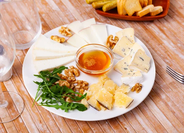 Slices Four Varieties Cheeses Plate Sweet Honey Walnuts Arugula Leaves — Stock Photo, Image