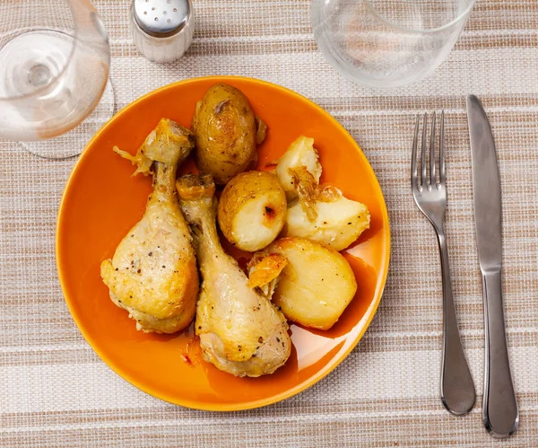 多汁的烤鸡腿和土豆 桌上放着银器 — 图库照片