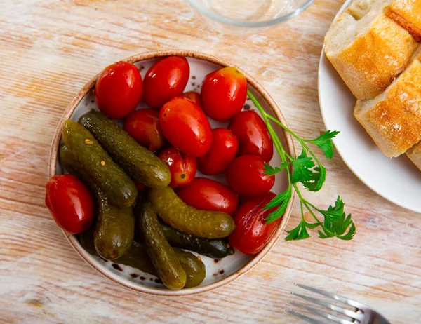 キッチンテーブルの上のプレート上の自家製漬物のガーキンスとトマト マリネ食品 — ストック写真