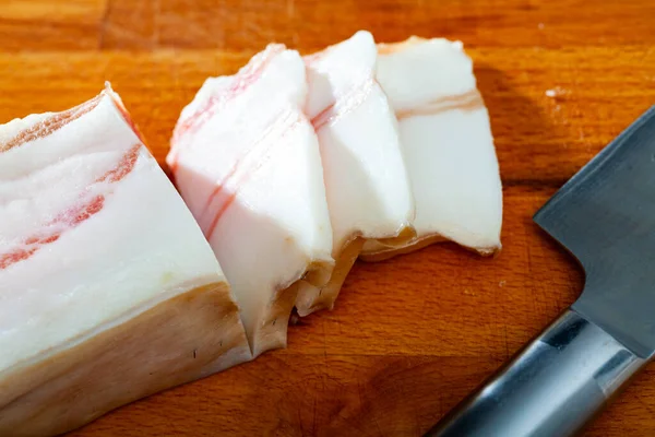 木の背景に塩豚の腹をスライス食欲をそそる 伝統的なスラブの肉スナック — ストック写真