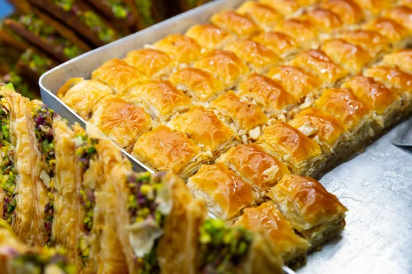 Oriental sweets pahlava with nuts, pistachio and honey on a tray