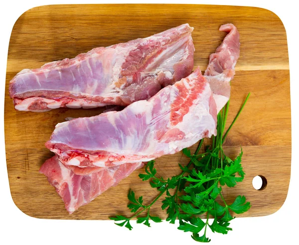 木のまな板で調理する準備ができて新鮮な緑と生肉の豚肉のリブのスラブ 白地に隔離された — ストック写真