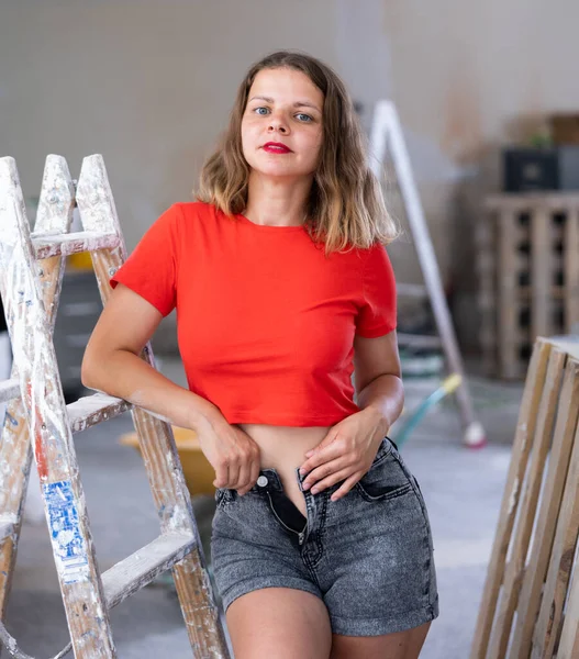 Verspielte Junge Frau Rotem Shirt Und Jeanshose Posiert Renoviertem Zimmer — Stockfoto