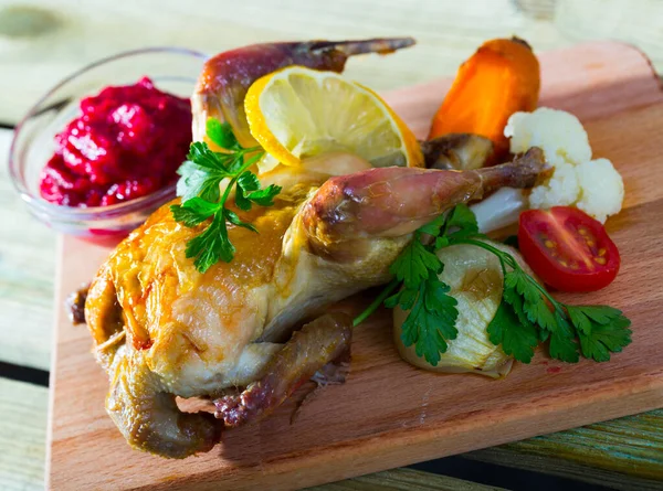 stock image Delicious grilled hen served on wooden board with cranberry sauce broiled vegetables