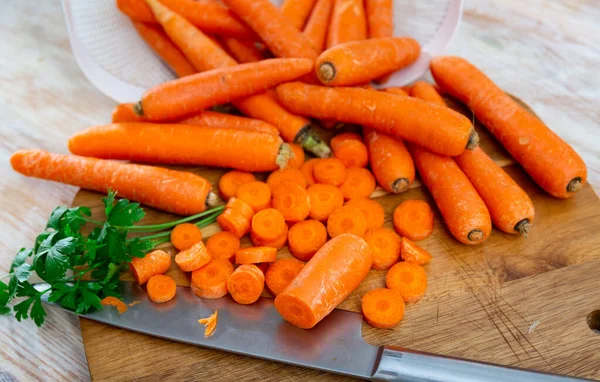 用欧芹把一堆堆新鲜的甜胡萝卜放在木板上 准备食物概念 — 图库照片