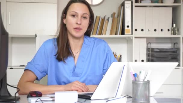 Μια Σίγουρη Νεαρή Γυναίκα Γιατρός Τυπώνει Μια Κάρτα Εξωτερικών Ασθενών — Αρχείο Βίντεο