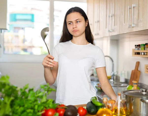 Μια Νεαρή Μπερδεμένη Και Στοχαστική Γυναίκα Αποφασίζει Μαγειρέψει Στην Κουζίνα — Φωτογραφία Αρχείου