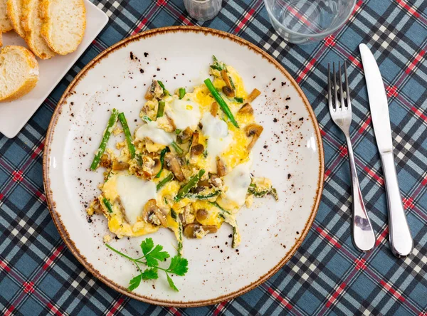 Traditional Spanish breakfast is a Revuelto, which is an omelet with chicken and mushrooms with asparagus. Decorated with a ..sprig of fresh greenery