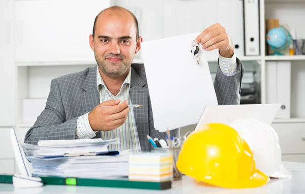 オフィスのキーを手に男性建築家の笑顔 — ストック写真