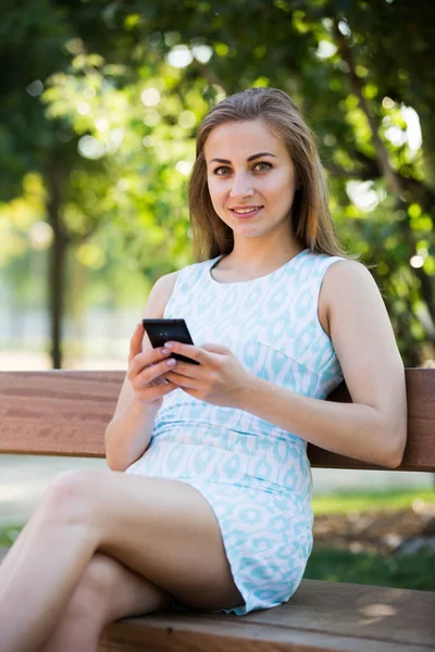 Gelukkig Russisch Meisje Zitten Een Bank Met Behulp Van Telefoon — Stockfoto