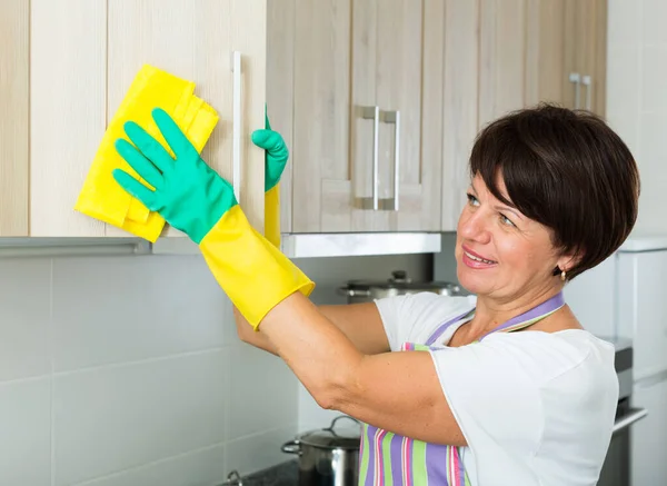 Mulher Madura Positiva Limpando Superfícies Com Espanador Detergente Casa Dentro — Fotografia de Stock