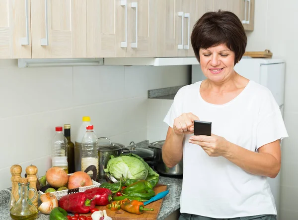 Ritratto Donna Matura Felice Guardando Telefono Cellulare Mentre Piatto Cucina — Foto Stock