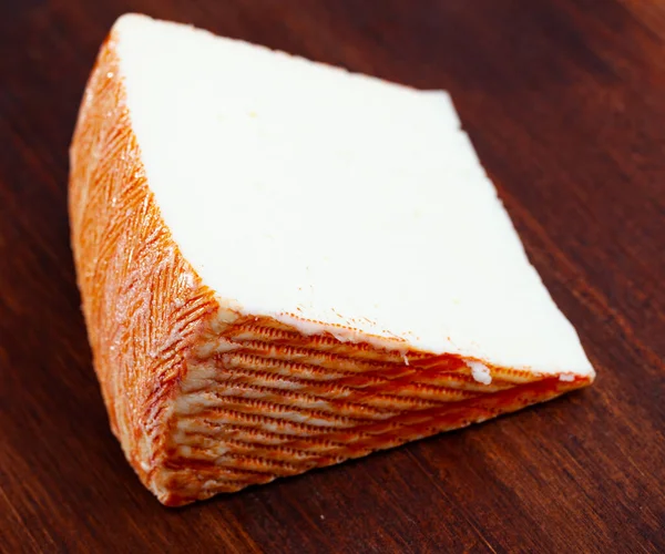 木製の背景に羊のミルクから伝統的なスペインの半ハードチーズのスライス — ストック写真