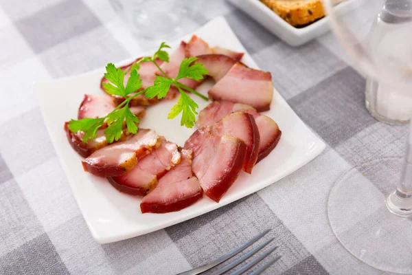 スライスされた豚肉の腹を食欲をそそる緑で飾られたプレート上で夕食のために提供 伝統的なスラブの肉スナック — ストック写真