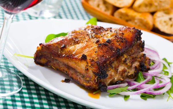 Grilled Pork Ribs Rack Garnished White Plate Arugula Red Onion — Stock Photo, Image