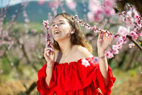 Portrét Šťastné Dívky Červených Šatech Kvetoucí Jarní Zahradě — Stock fotografie