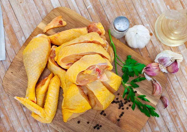 新鲜的未加工切碎的鸡块放在木制切菜板上 准备在家庭厨房里烹调 配上新鲜的 胡椒和大蒜 — 图库照片