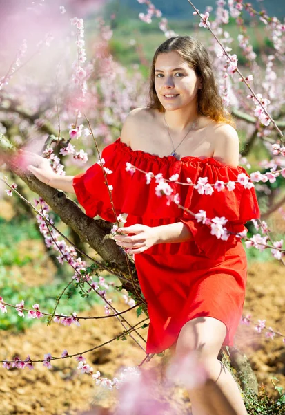 Ευτυχισμένο Κορίτσι Στον Ανοιξιάτικο Κήπο Ροδάκινο Κόκκινο Φόρεμα — Φωτογραφία Αρχείου