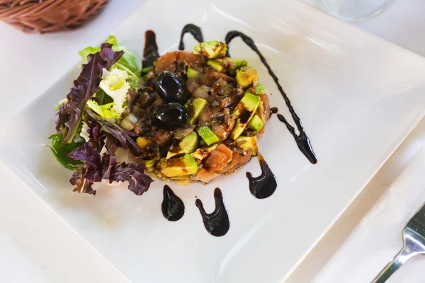 フランス料理の人気料理は アボカドとスモークサーモンのタルタル 緑とオリーブを添え 醤油で霧雨 — ストック写真