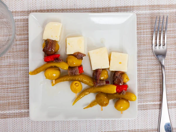 Four gildas, Spanish snack, served on plate. Pepper olive cheese and anchovy skewers.