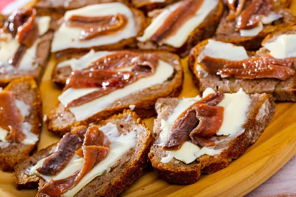 Canapés Pão Preto Com Manteiga Anchovas Tábua Madeira — Fotografia de Stock