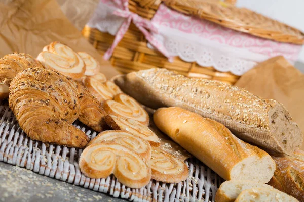 Assortment Fresh Baked Goods Wicker Mat Basket Wooden Background — Stock Photo, Image